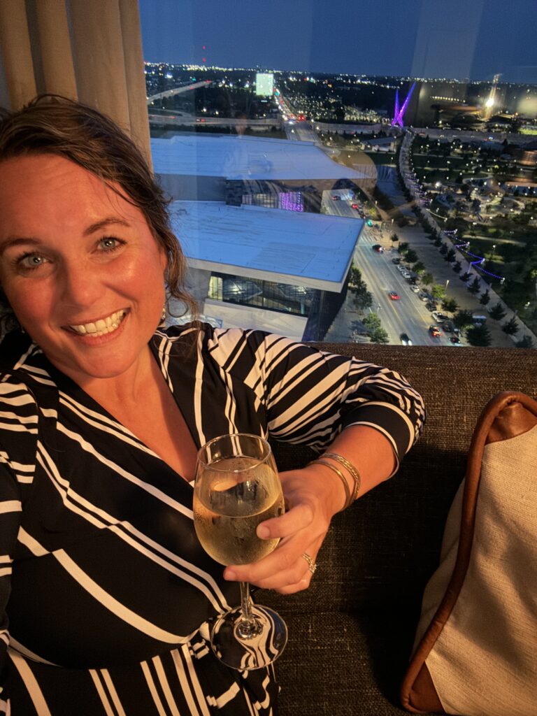 blog author with a glass of wine sitting by the window at omni okc