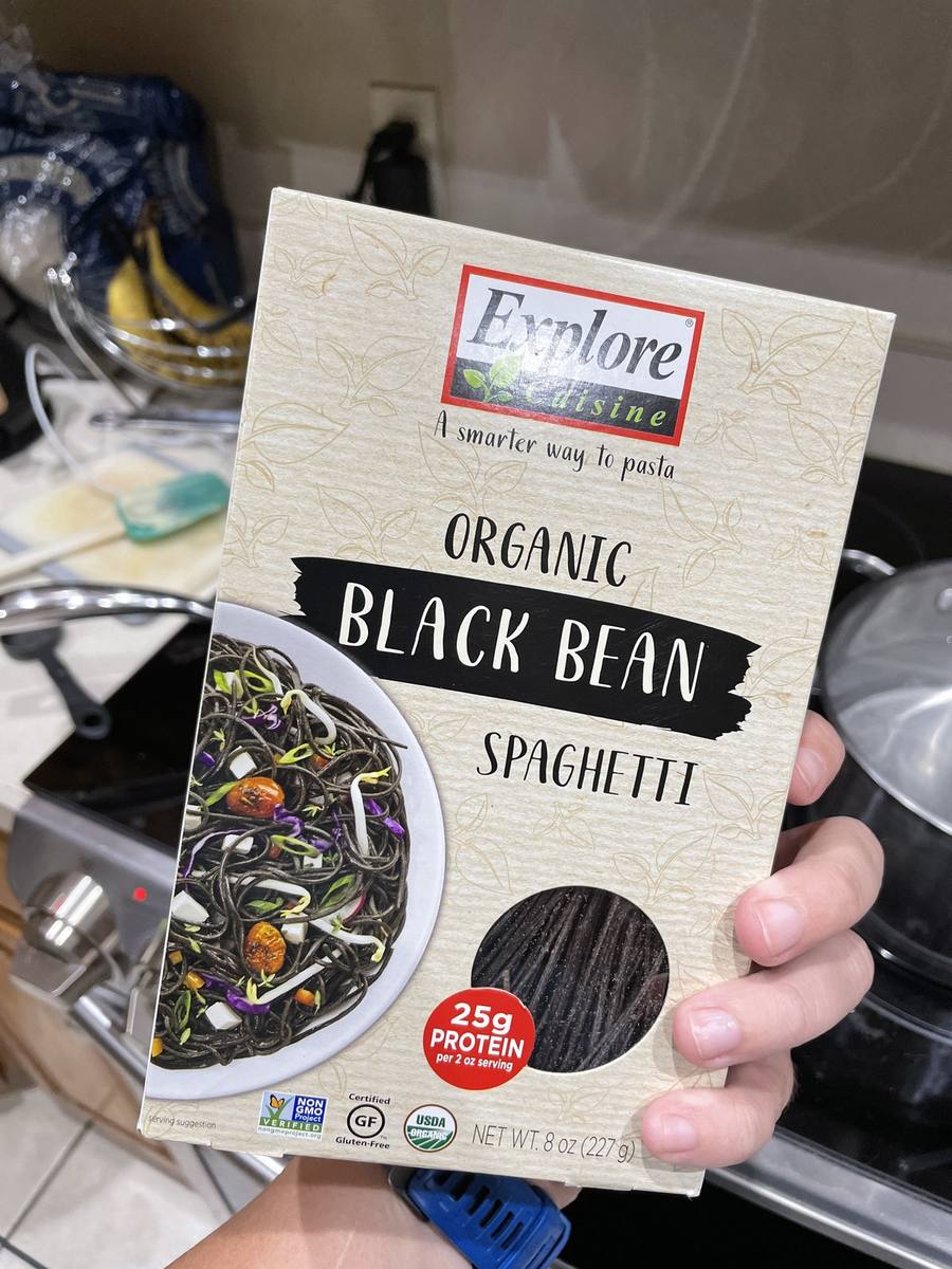 A box of certified gluten free organic black bean spaghetti held in a kitchen.