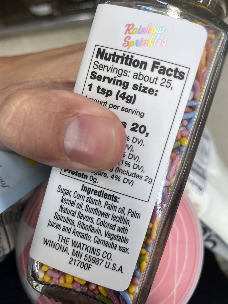 An ingredient label on a jar of rainbow sprinkles listing natural flavors among the ingredients.
