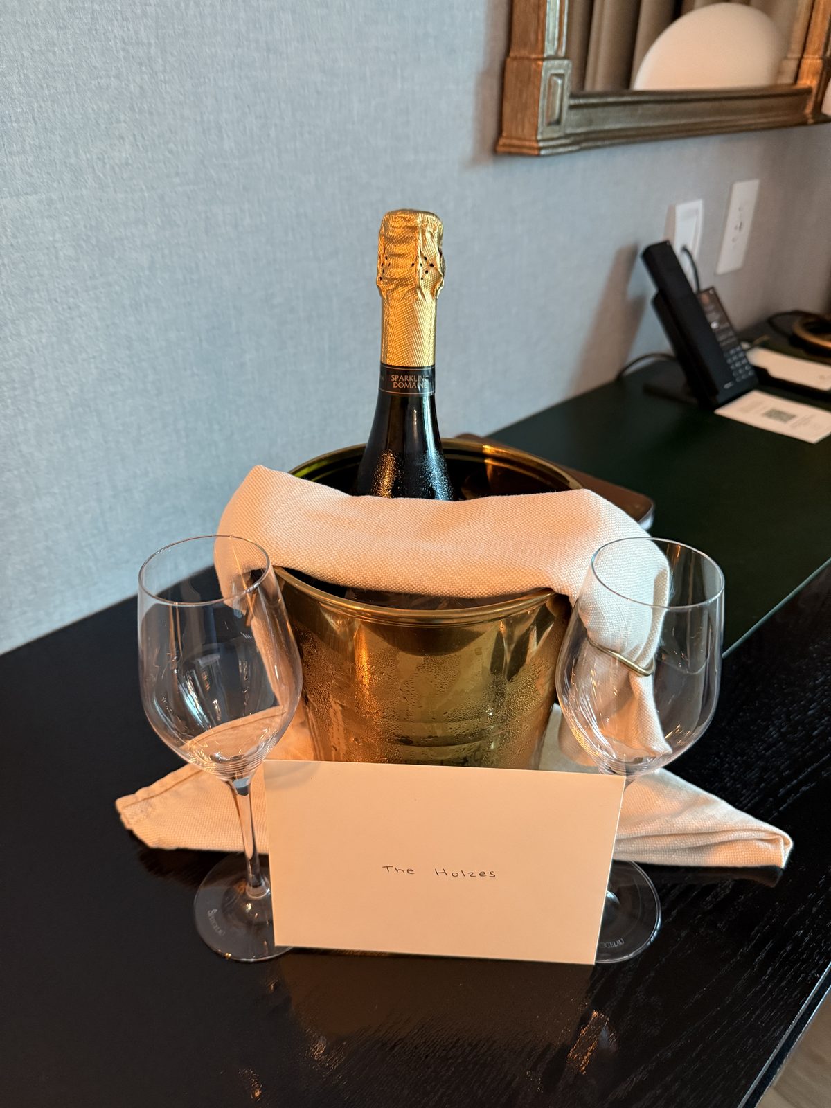 Welcome champagne in a gold ice bucket with two glasses and a handwritten card in a Terrace Suite at The Global Ambassador