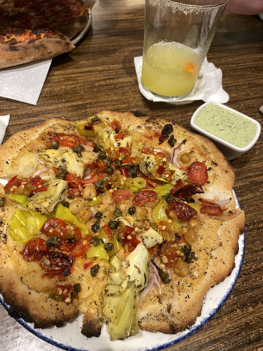 A gluten free pizza topped with artichokes, chickpeas, pepperoncini and roasted tomatoes at Hall’s Pizza Kitchen.
