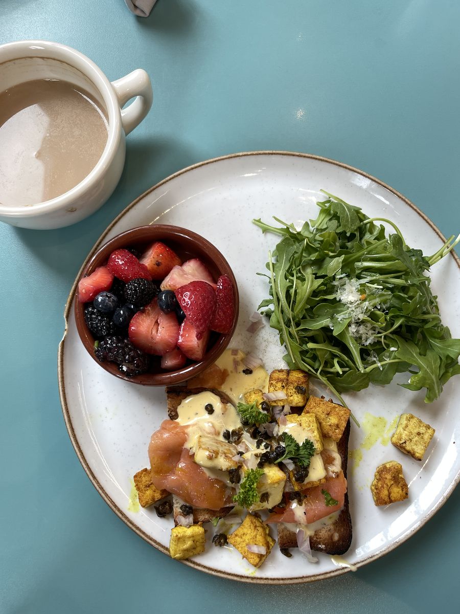 A gluten free smoked salmon benedict with turmeric tofu, hollandaise and capers, served with berries and an arugula salad at Hatch.