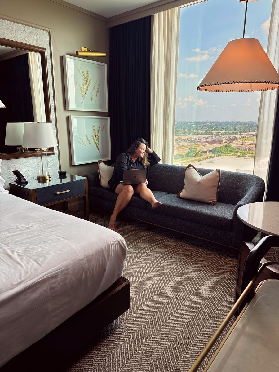 A hotel room at the Omni in downtown Oklahoma City, with a sofa by a floor to ceiling window.